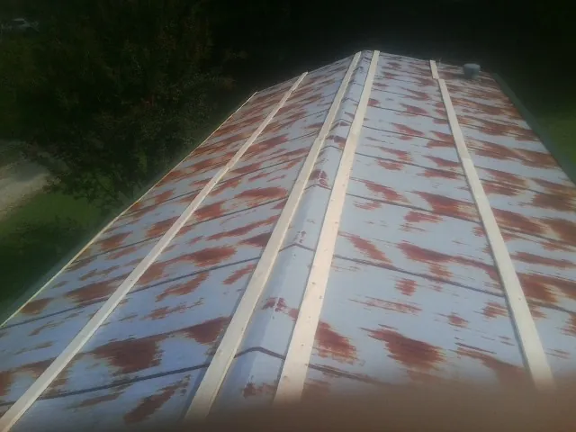 Rusted metal roof panels with new wood purlins before replacement — Storm Damage Roof Repair in Rougemont by Roofing Brothers