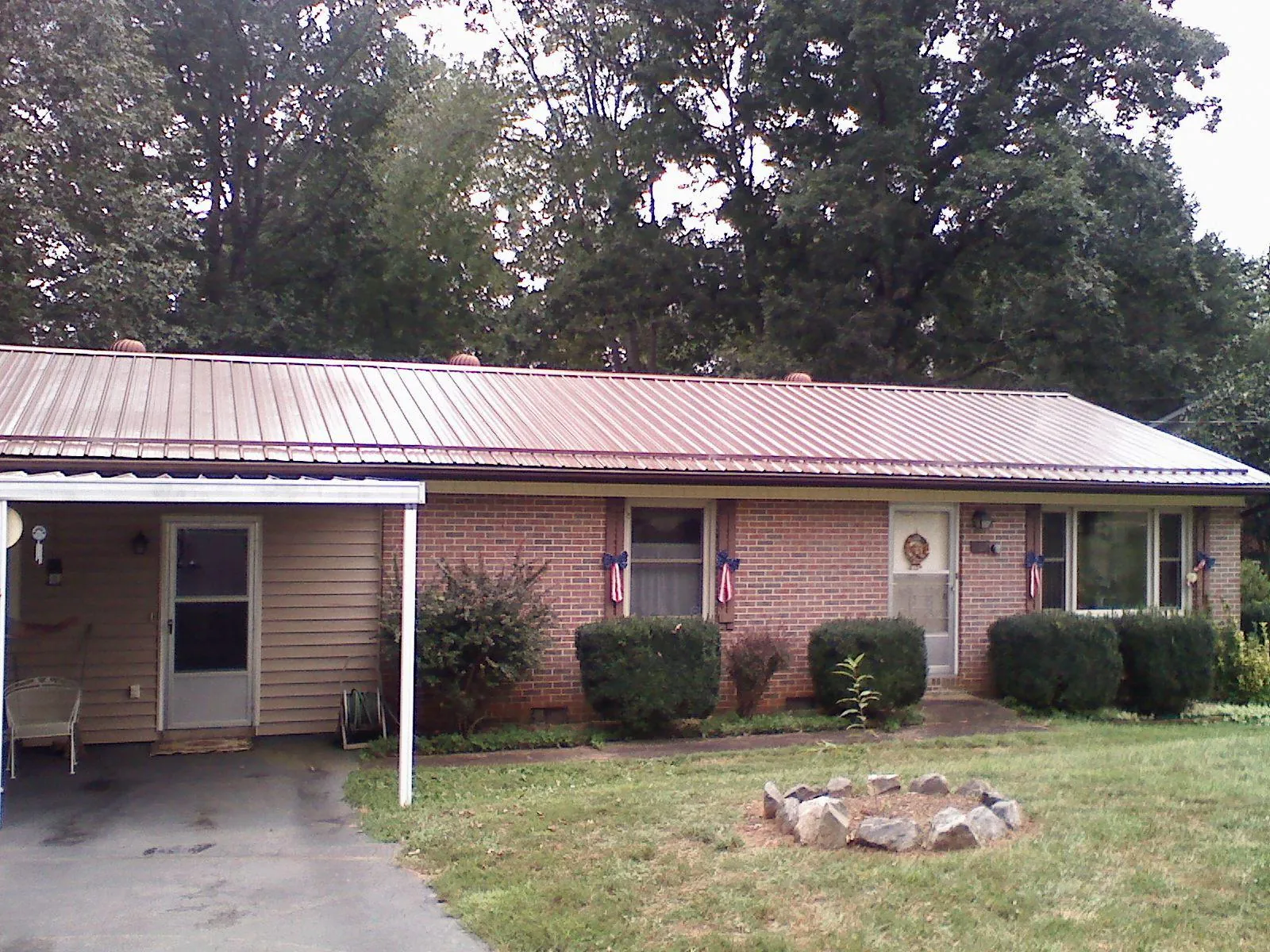 Bronze metal roof and carport on a brick ranch home — Roof Repair work by our crew in Rougemont